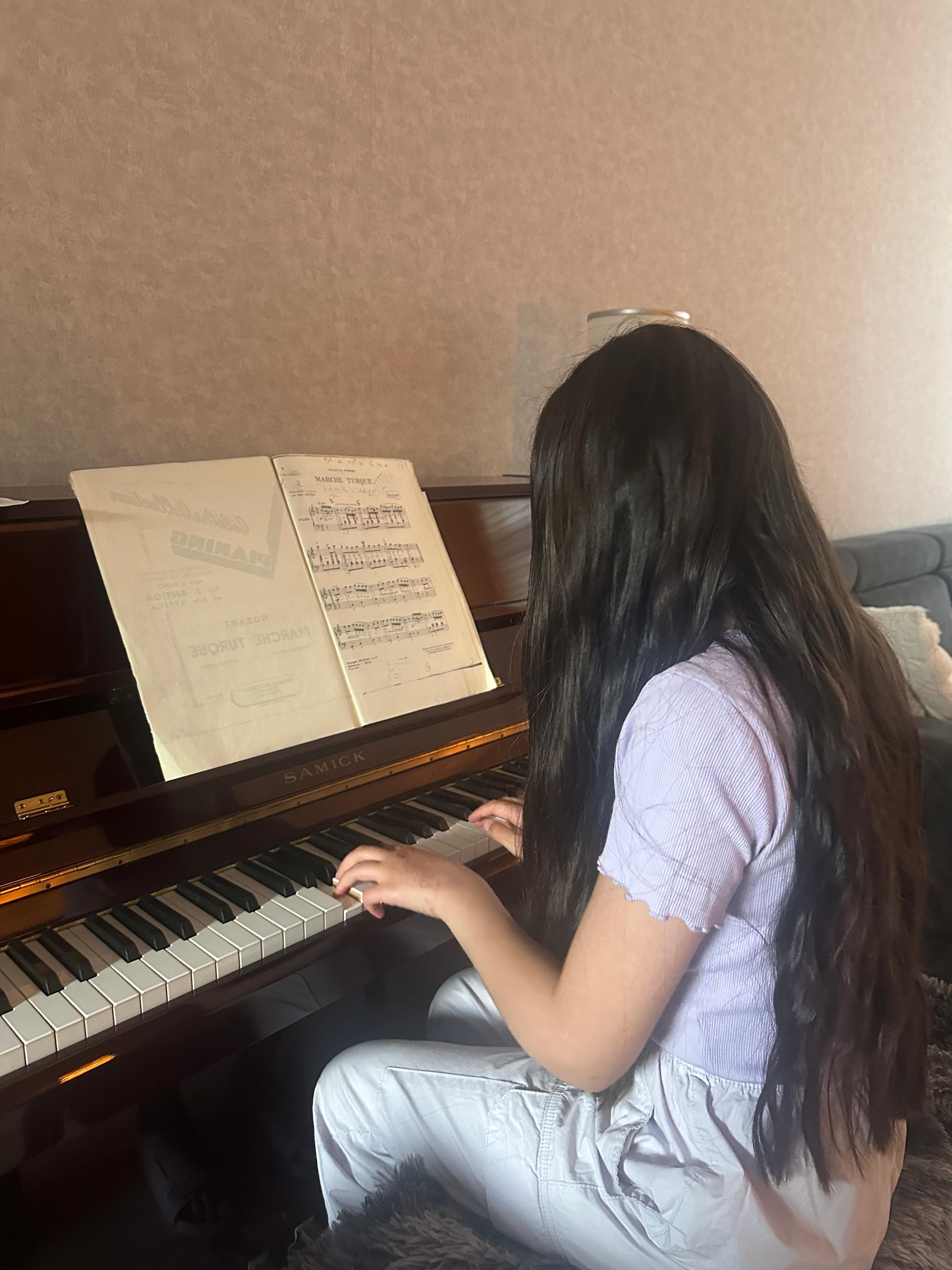 Leerling speelt piano uit bladmuziek tijdens een pianoles