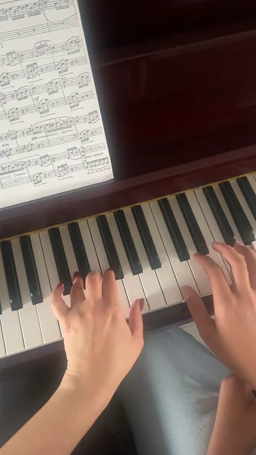 Close-up van handen die piano spelen uit bladmuziek